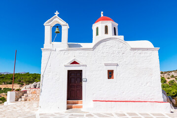 Fototapeta premium White Chapel of Agia Kyriaki with small red dome, on top of a cliff, near Pigadia, Karpathos island, Greece