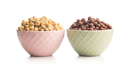 Breakfast cereal rings and chocolate balls in bowls isolated on white background.