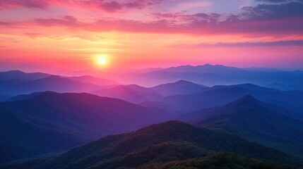 Obraz premium Breathtaking sunrise over layered mountain ranges with vibrant colors and misty valleys in the background