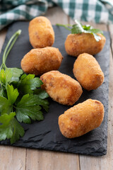 Fried cod croquettes on wooden table. Traditional spanish food