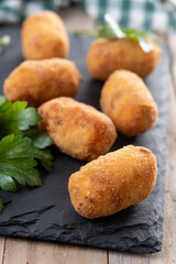 Fried cod croquettes on wooden table. Traditional spanish food
