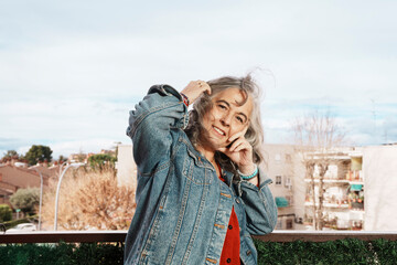 Woman with white hair smiling on her balcony at home