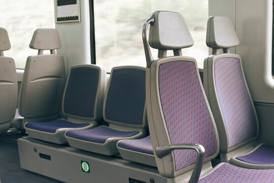Empty train seats with purple upholstery and window view