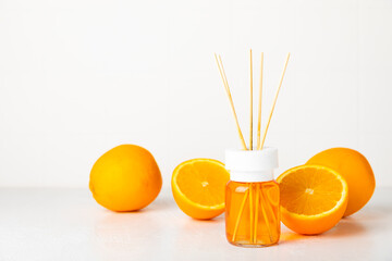 Obraz premium Aromatic reed air freshener on wooden table.Diffuser with natural fruity, floral, spicy aroma.interior scent. Luxury perfume for the home.Orange, lime, coffee, cinnamon, star anise, vanilla and orchid
