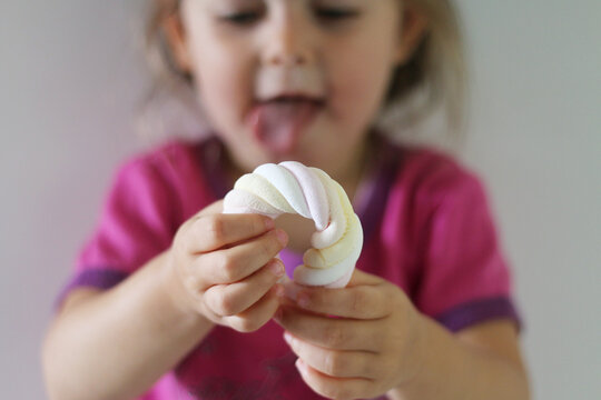Close-up of a young Girl playing with a marshmallow flump