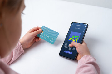 Young girl holding a credit card, symbolizing payment for video games, in-game purchases, or virtual skins. A concept of digital spending