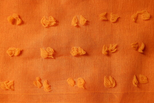 Pumpkin orange color dobby cotton fabric texture seamless with beautiful closeup detail fabric. Luxury dobby cotton textile pattern with soft and delicate material.