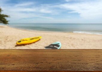 Obraz premium Wooden table top on the beach or sea.Party on the beach sunshine time concept.For montage product display or design key visual layout.View of copy space.