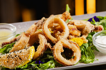Sea food. Close up photo with a dish made of fried squid seafood with mixed salad along it. Mediterranean and Greek cuisine.