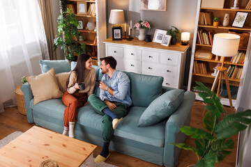 Couple having fun drinking coffee and relaxing at home