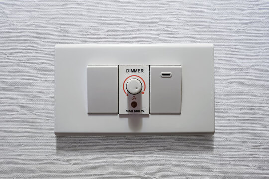 Electrical light dimmer switch on the wall. Brightness controller. Electricity consumption. Home appliance. Household equipment