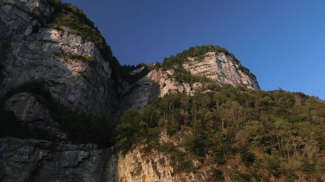 Drone shot of beautiful mountain and forests, in summer afternoon under clear blue sky