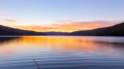Obraz premium Serene lake at sunset with colorful reflections and calm waters.