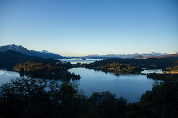 Traveling in nature, Patagonia lake, mountains in the background, calm horizon, blue sunset