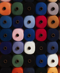 Fototapeta premium Colorful Yarn Spools: A vibrant array of tightly wound yarn spools in various colors creates a captivating tapestry of texture and hues, perfect for textile design and craft projects. 