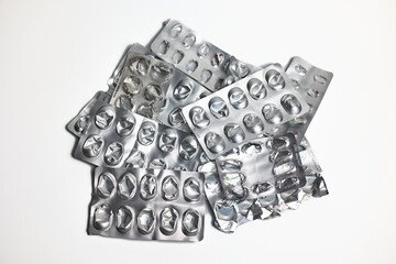 Pile of empty pill blister packs on white background. Treatment and medication concept