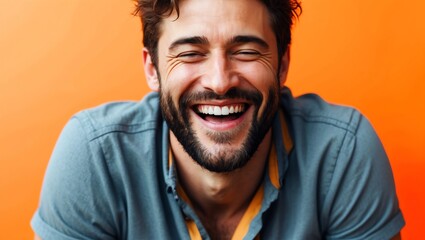 Obraz premium Man laughing in orange studio, close up 