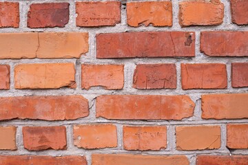 Red brick wall texture background. Brick wall with scratches and cracks. Background of old brick wall.