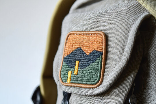 Handmade fabric patch on backpack, featuring mountains and colors