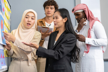 Diverse team brainstorming business meeting, professional presentation with data charts, team collaboration for project planning, modern corporate office teamwork, group discussing business strategies