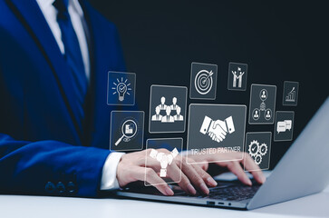 Trusted Partner and Collaboration Concept. Businessman using a laptop with icons trust, partnership, and collaboration. teamwork, reliability, and value of trusted business relationships. Trustworthy,