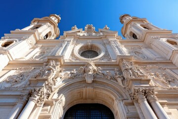 This image features the intricate facade of an ornate building, showcasing exquisite architectural details set against a clear blue sky, evoking grandeur and historical significance.