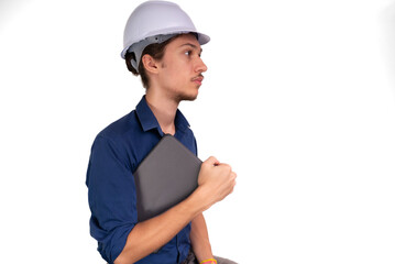 Portrait of young architect wearing white helmet, working with laptop and looking aside. Isolated on white background.