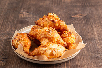 Freshly baked croissants with almonds on a plate