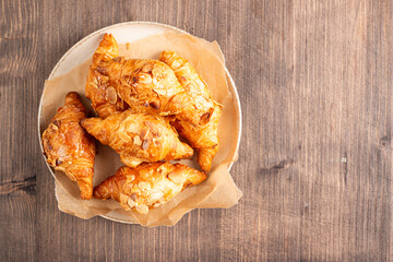 Freshly baked croissants with almonds on a plate