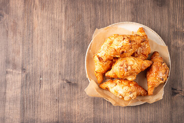 Freshly baked croissants with almonds on a plate