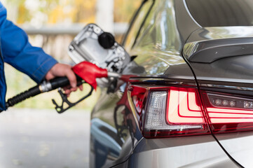 Refueling a Car at Gas Station. Close-Up of Red Nozzle.