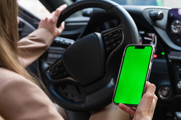 Driver Holding Smartphone with Green Screen in Car