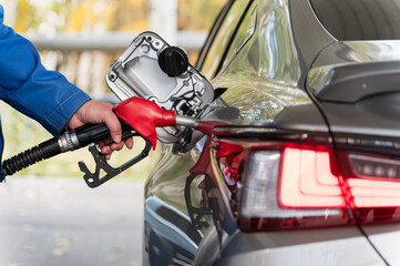 Refueling a Car at Gas Station. Close-Up of Red Nozzle.