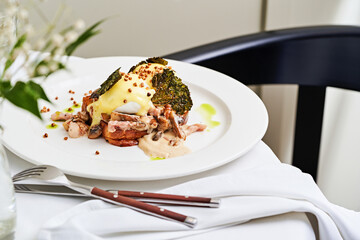 A beautifully arranged plate showcases a gourmet dish with succulent meat, vibrant greens, and rich sauce. The presentation is elegant, enhancing the dining experience with fine details