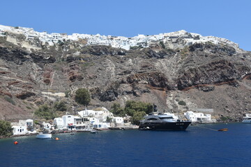 A luxury yacht and sail boat cruising in the crater of Santorini Island in the Mediterranean Sea, Greece