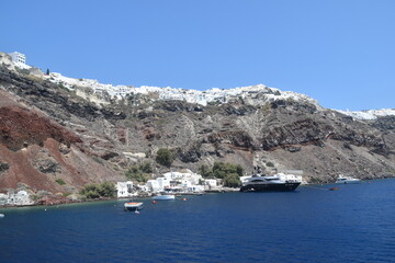 A luxury yacht and sail boat cruising in the crater of Santorini Island in the Mediterranean Sea, Greece