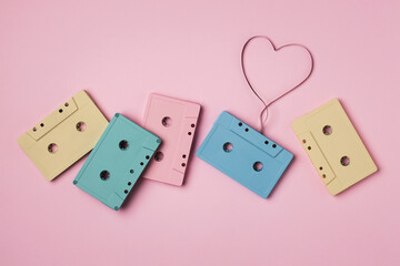 Color vintage audio cassettes with a heart on a pink background.