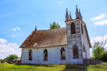Fototapeta premium A small, old church with a steeple and a cross on top