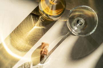 Different glasses for wine, cocktails, drinks, long sun shadow on a light beige background. The concept of wine tasting or summer vacation.