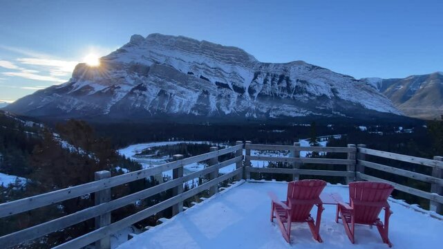 Slow motion Banff National Park tracking shot over wooden viewpoint chairs tourist attraction photo opportunity.
