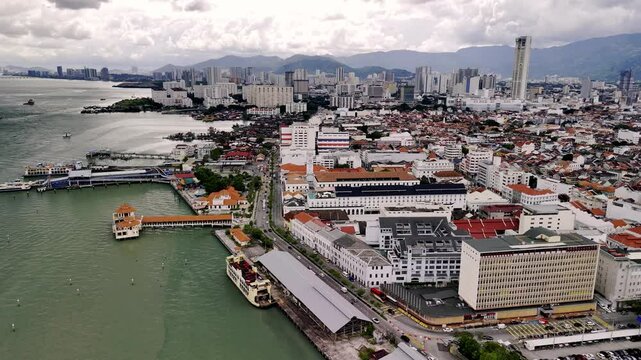 Aerial panorama capturing george town's heritage, chew jetty waterfront alongside urban malaysian skyline