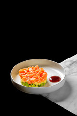Fresh salmon tartare with avocado on elegant plate