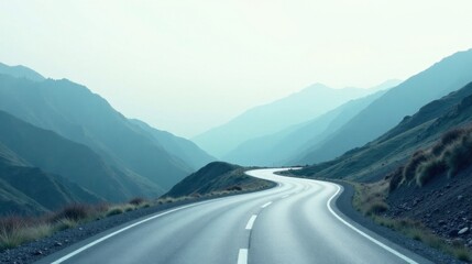 Asphalt Ribbon Winding Through Serene Mountain Landscape Under a Pale Sky