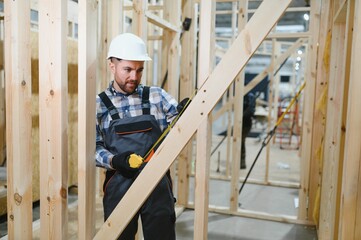 Worker carpenter assembling a modular house