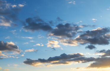 Fototapeta premium Beautiful orange sunset clouds on the blue sky. Sky background.