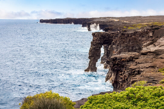 The Holei Sea Arch rises from the Pacific Ocean along lava rock cliffs at the end of the Chain of Craters Road in Hawaii Volcanoes National Park on the Big Island of Hawaii.