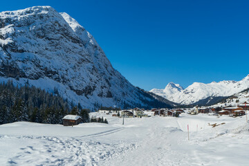 Scenic Alpine Landscape with Snowy Peaks and Quaint Village in Austria