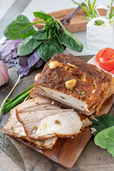 Baked piece of pork - ham. Delicious spicy meat. Spicy meat baked with garlic and chili peppers. A piece of baked meat with spices and vegetables on the table