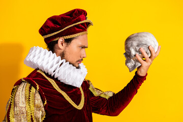 Nobleman in Historical Attire Posing with Skull Against Yellow Backdrop, to be or not to be