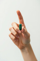 Fototapeta premium Close Photo Hand Holding Green Medical Capsule